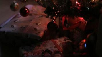 versierde kerstboom met geschenken. kerstmis en nieuwjaarsviering. vakantie kersttafereel. kerstcadeaus onder de kerstboom. video