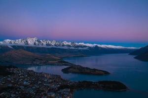 puesta de sol sobre el río y las montañas nevadas foto