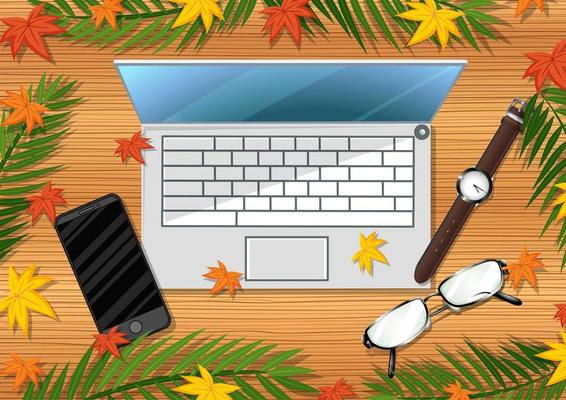 Top view of wooden table with office objects and leaves element