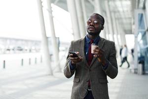 Hombre de negocios afroamericano escucha la música en su teléfono inteligente foto