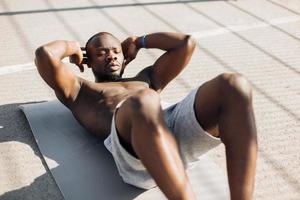 hombre afroamericano trabaja sus abdominales foto