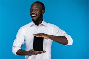 Cute man smiles and holds a tablet photo