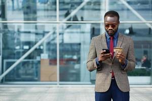 Stylish African American black businessman types information from his credit card photo