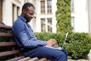 Feliz hombre afroamericano trabaja en su computadora portátil foto