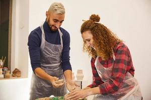 Man and girl are shaping a vase and smiling