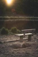 Grey wooden bench at a lake photo