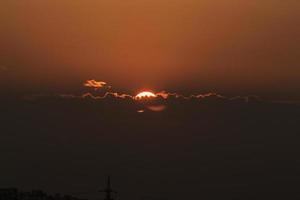 Sun behind clouds at night photo