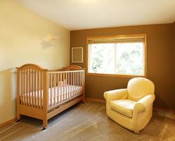 Baby room with crib and yellow chair. photo