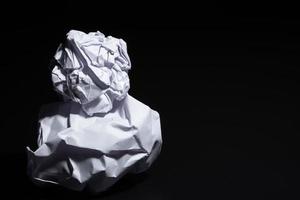 Crumpled paper on black background photo