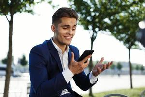 Man looking confused holding his phone photo