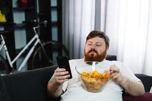 Pretty fat man smiles checking his smartphone photo