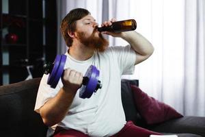 Man drinking a beer while lifting weights photo