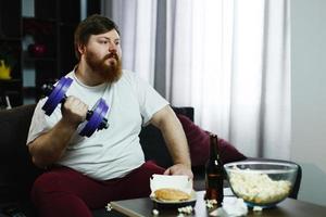 Man lifting weights on the sofa photo