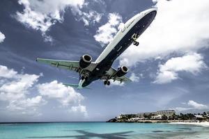 S t. Martin, 2013-turistas se agolpan en la playa de maho mientras un avión de vuelo bajo se acerca a la pista sobre la costa foto