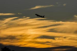 Airplane over golden hour sunset photo