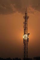 Silhouette of a radio tower with setting sun