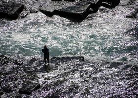 Sydney, Australia, 2020 - Man fishing while wading in the water photo
