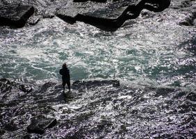 Sydney, Australia, 2020 - Hombre pescando mientras vadea en el agua foto