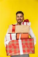 chico guapo sonriente sosteniendo cajas de regalo foto