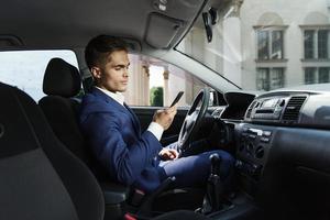 hombre revisando su teléfono en el coche foto