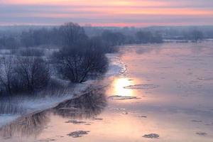 wintry sunrise on river photo