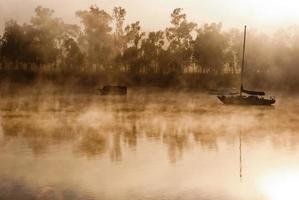 Foggy morning on a river with boats