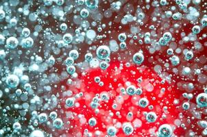 Air bubbles in a liquid. Abstract red background. Macro photo