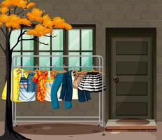 Many clothes hanging on a clothes rack in front of the house scene vector