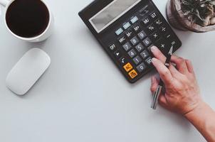 Top view of person using a calculator photo