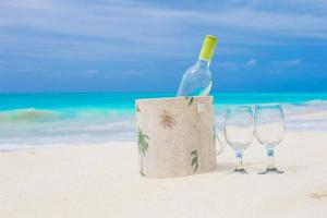 White wine and glasses on a beach photo