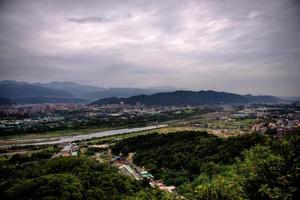 Aerial view of a road in a city under gray clouds photo