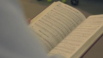 Over the shoulder shot of a hymn book 4k video