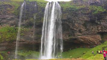 cachoeiras altas na Islândia com turistas 4k