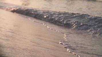 vågor som rullar upp till stranden i slow motion video