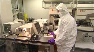 Scientist in safety suit doing lab work video