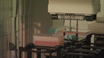 Robot científico colocando viales en rack video