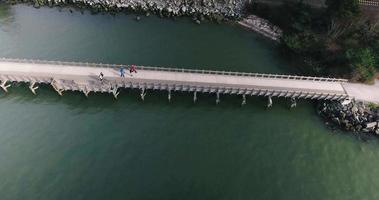 drone descendiendo cerca de un puente sobre peatones video