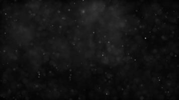 Soft little particles floating and fading on 4K dark background video