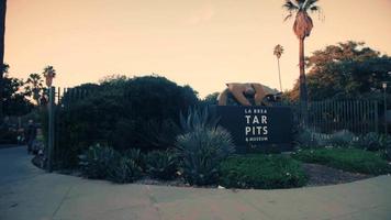 Tracking shot going right of La Brea Tar Pits and Museum entrance in 4K video