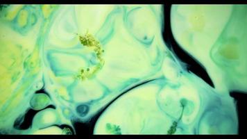 Yellow and blue paint mixing to create green bubbles and shapes video