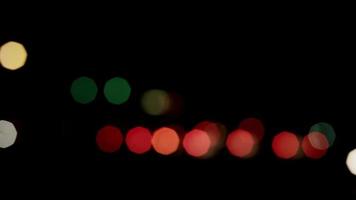Bokeh lights of vehicles circulating slowly in both directios of the street in 4K video
