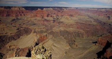 Prise de vue panoramique lente allant à droite du canyon rouge avec des arbres au premier plan en 4k video
