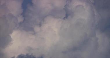 Time lapse of white giant cumulus clouds moving fast and disappearing on blue sky in 4K video