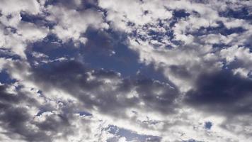 time-lapse van grijze altocumulus wolken bewegen op blauwe hemel in 4k video