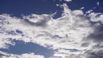 Time lapse of big group of altocumulus clouds moving slowly from right to left on blue background in 4K video