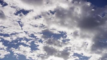 Time lapse of altocumulus clouds moving from right to left of the scene with sunlight rays behind in 4K video