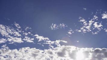 Lapso de tiempo de grandes grupos de nubes altocúmulos moviéndose lentamente en el cielo azul con destellos en 4k video