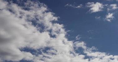 Time lapse of small and big cumulus clouds moving away from the camera on blue sky in 4K video