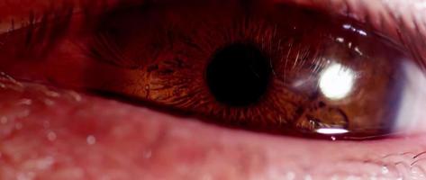 Close up of human eye with brown iris changing size of the pupil and trying to sleep in 4K video