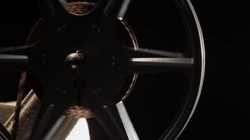 Close up of 8mm movie projector with detail of film reel spinning in 4K video